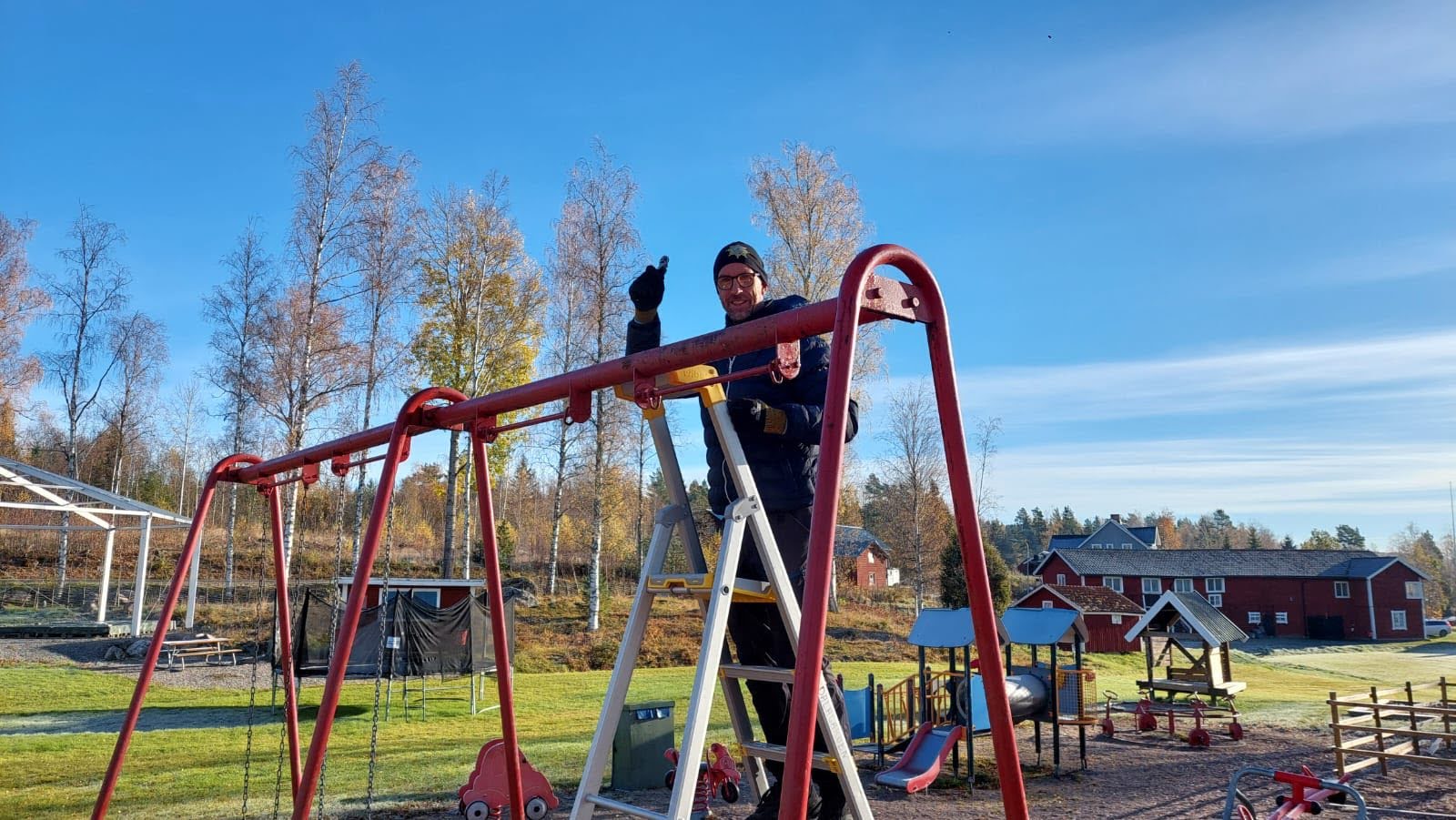 Volontär målar gungställning under arbetsdag på Dalagården