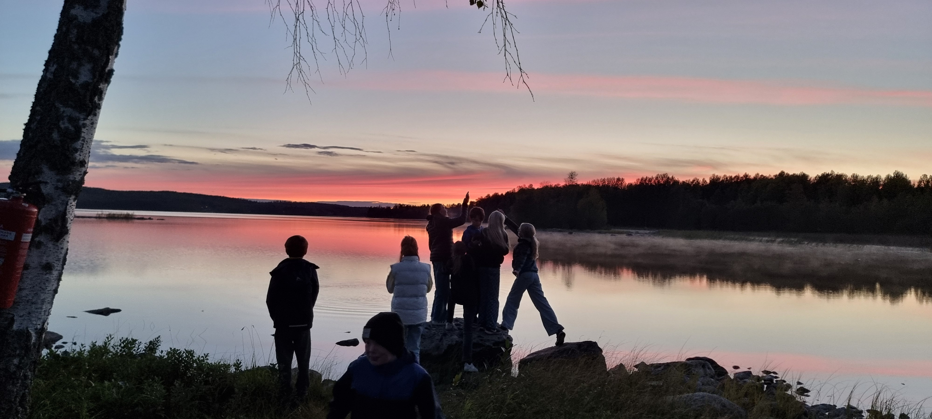 Kvällsstämning vid Liljan med solnedgång och barn på klipporna